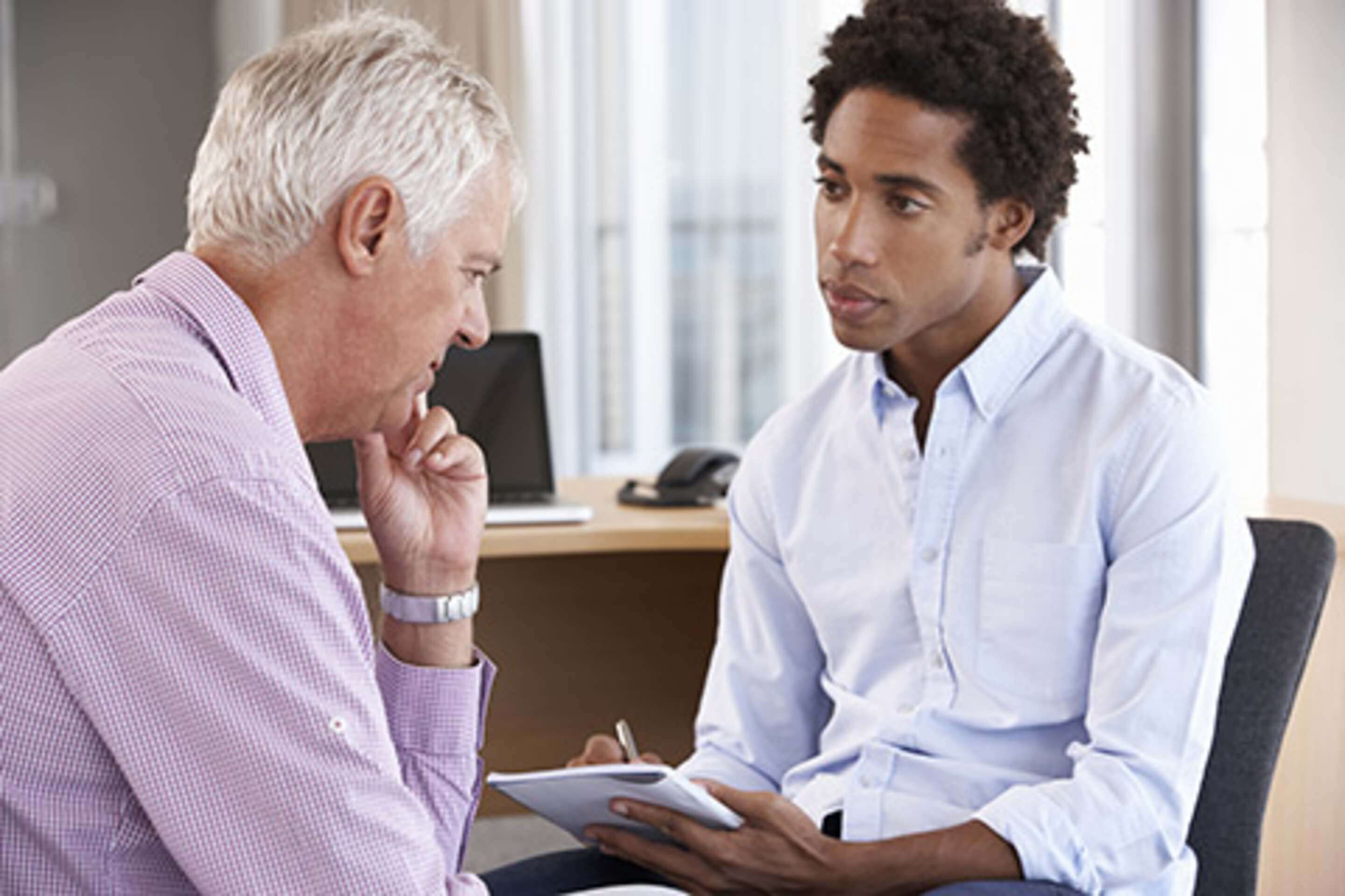 Older man talking to young doctor